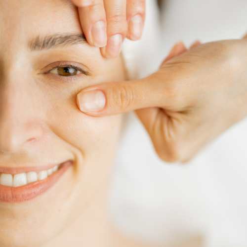 руки масажиста на обличчі